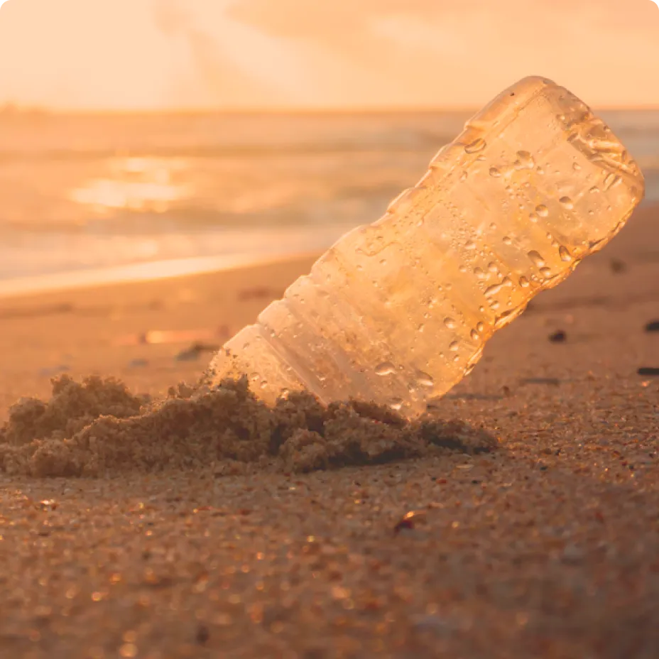 botella de plástico contaminando la playa